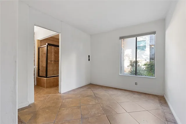 a view of an empty room with window and closet area