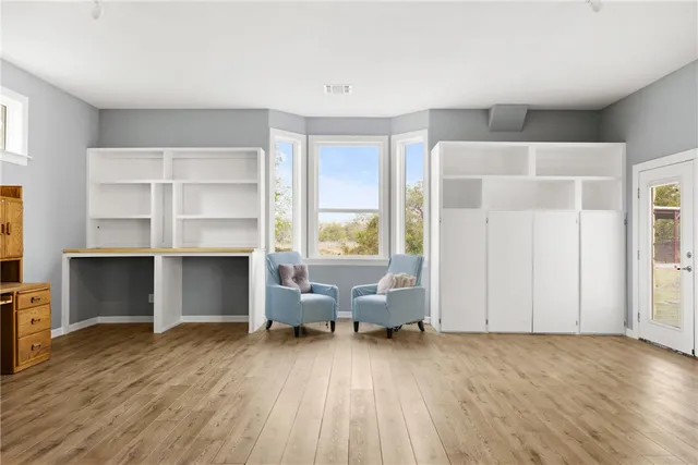 a view of an empty room with window and wooden floor