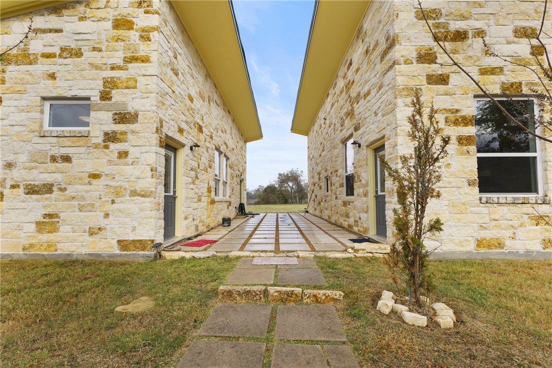 504 North Street Columbus, TX 78934 - Photo 3 of 29 View of side of property with stone siding and a yard