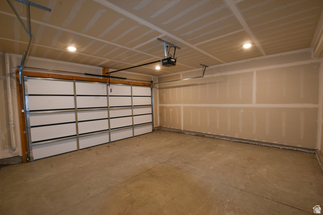 8087 South 615 East, Unit 3 Sandy, UT 84070 - Photo 23 of 23 Spacious garage featuring a sectional overhead door, automatic opener, concrete flooring, and recessed ceiling lighting