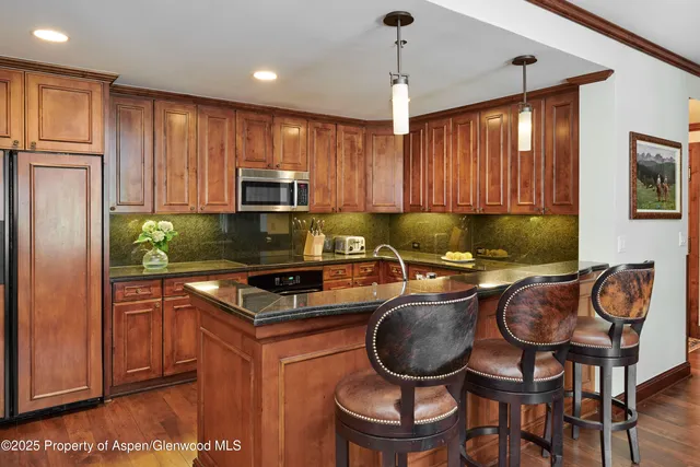 a kitchen with stainless steel appliances granite countertop a stove a sink and a refrigerator