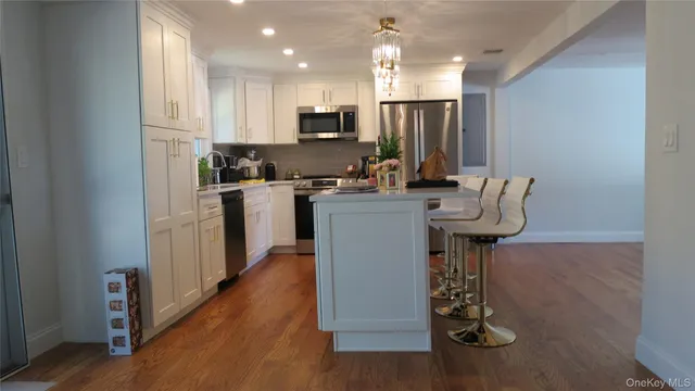 a kitchen with appliances a sink cabinets and wooden floor