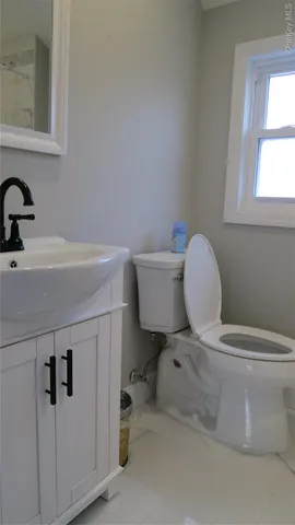 a bathroom with a sink a toilet and a window