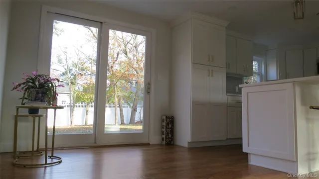 a view of empty room with wooden floor and window