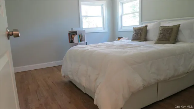 a large bed sitting in a bedroom next to a window and a wooden floor