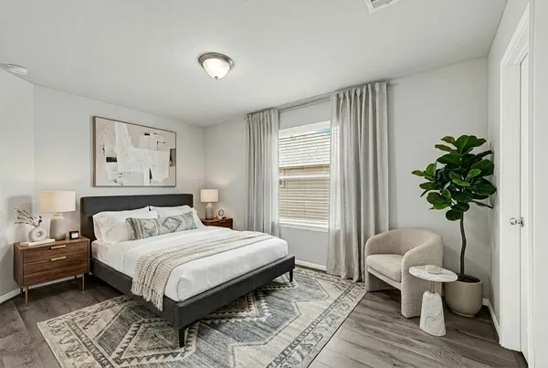 a bedroom with a large bed and a potted plant