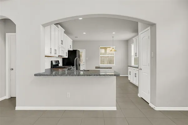a large bathroom with a granite countertop sink a mirror and a bathtub