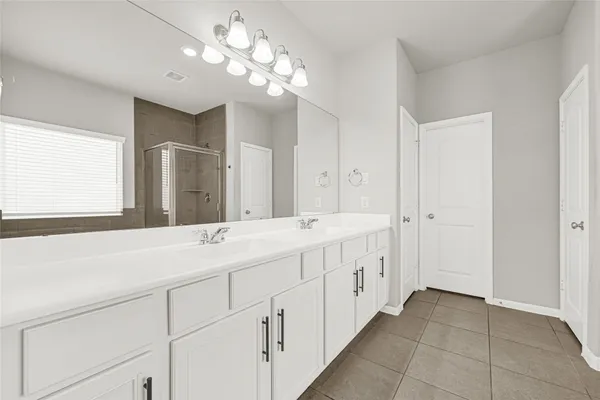 a bathroom with a double vanity sink and a mirror