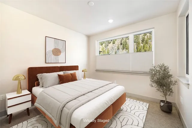 a bedroom with a bed and a potted plant