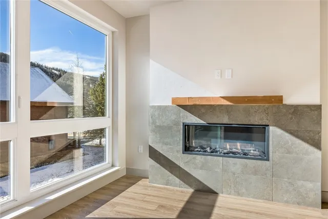 a living room with a fireplace furniture and a floor to ceiling window