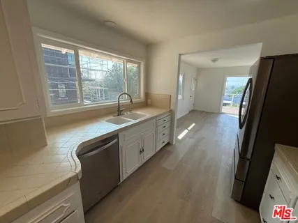 a large kitchen with a sink and a large window
