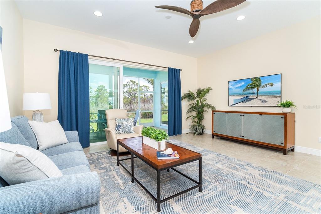 8952 Scallop Way Placida, FL 33946 - Photo 17 of 52 a living room with furniture a flat screen tv and a floor to ceiling window