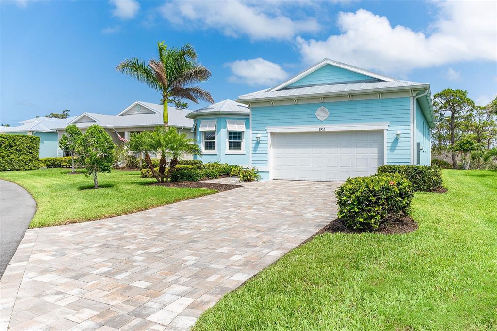 8952 Scallop Way Placida, FL 33946 - Photo 2 of 52 a front view of a house with a yard and garage