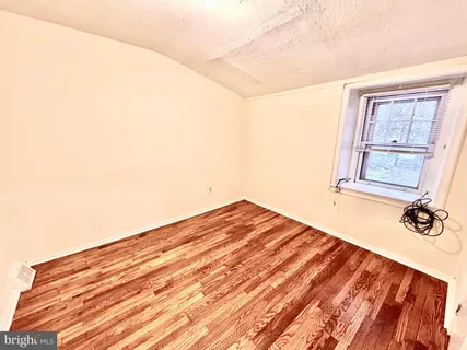 a view of a room with wooden floor and white walls