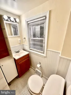 a bathroom with a toilet sink and mirror