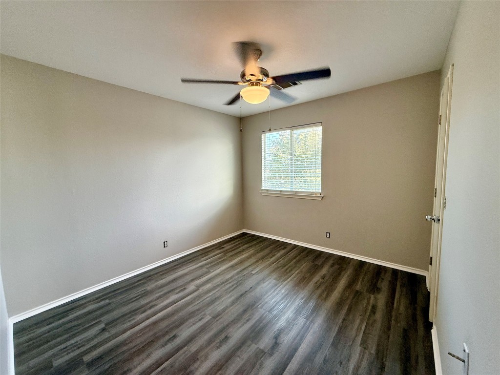 17212 Hamilton Point Circle Manor, TX 78653 - Photo 18 of 27 an empty room with wooden floor ceiling fan and windows