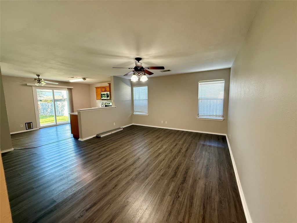 17212 Hamilton Point Circle Manor, TX 78653 - Photo 2 of 27 an empty room with wooden floor chandelier and windows