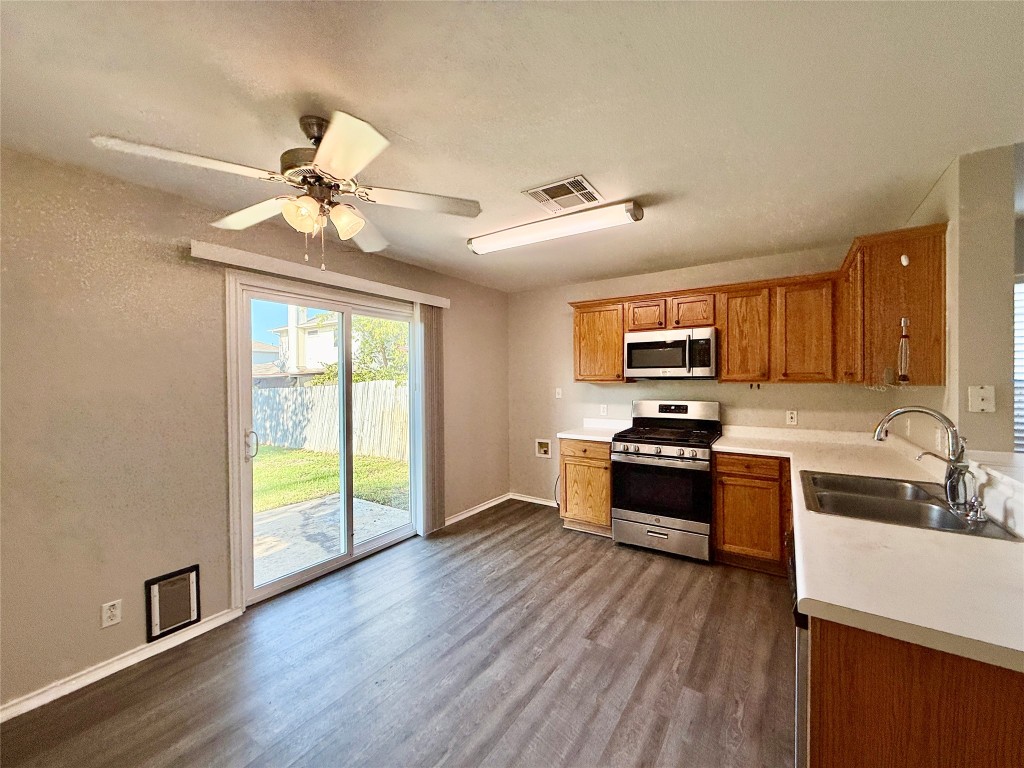 17212 Hamilton Point Circle Manor, TX 78653 - Photo 4 of 27 a large kitchen with stainless steel appliances granite countertop a stove and a wooden floors