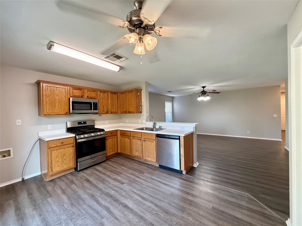 17212 Hamilton Point Circle Manor, TX 78653 - Photo 5 of 27 a kitchen with stainless steel appliances granite countertop a sink a stove and a wooden floors