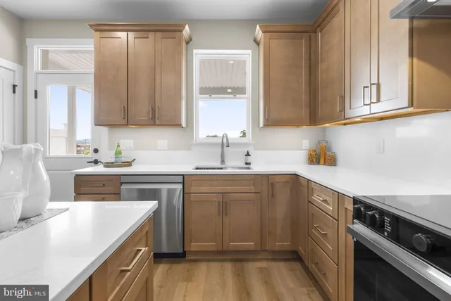 a kitchen with a stove a sink and a wooden floor