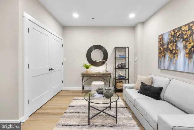 a living room with furniture a rug and a wall painting