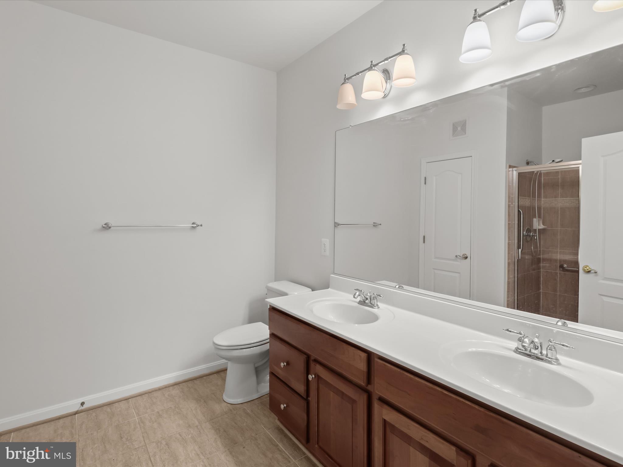 7325 Brookview Road, Unit 208 Elkridge, MD 21075 - Photo 19 of 31 a bathroom with a double vanity sink mirror and toilet