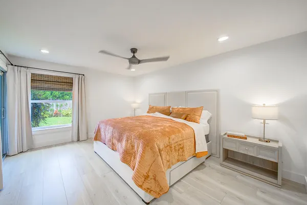a bedroom with a bed and a large window
