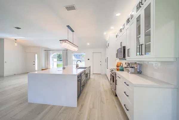 a kitchen with kitchen island a sink stove and wooden cabinets