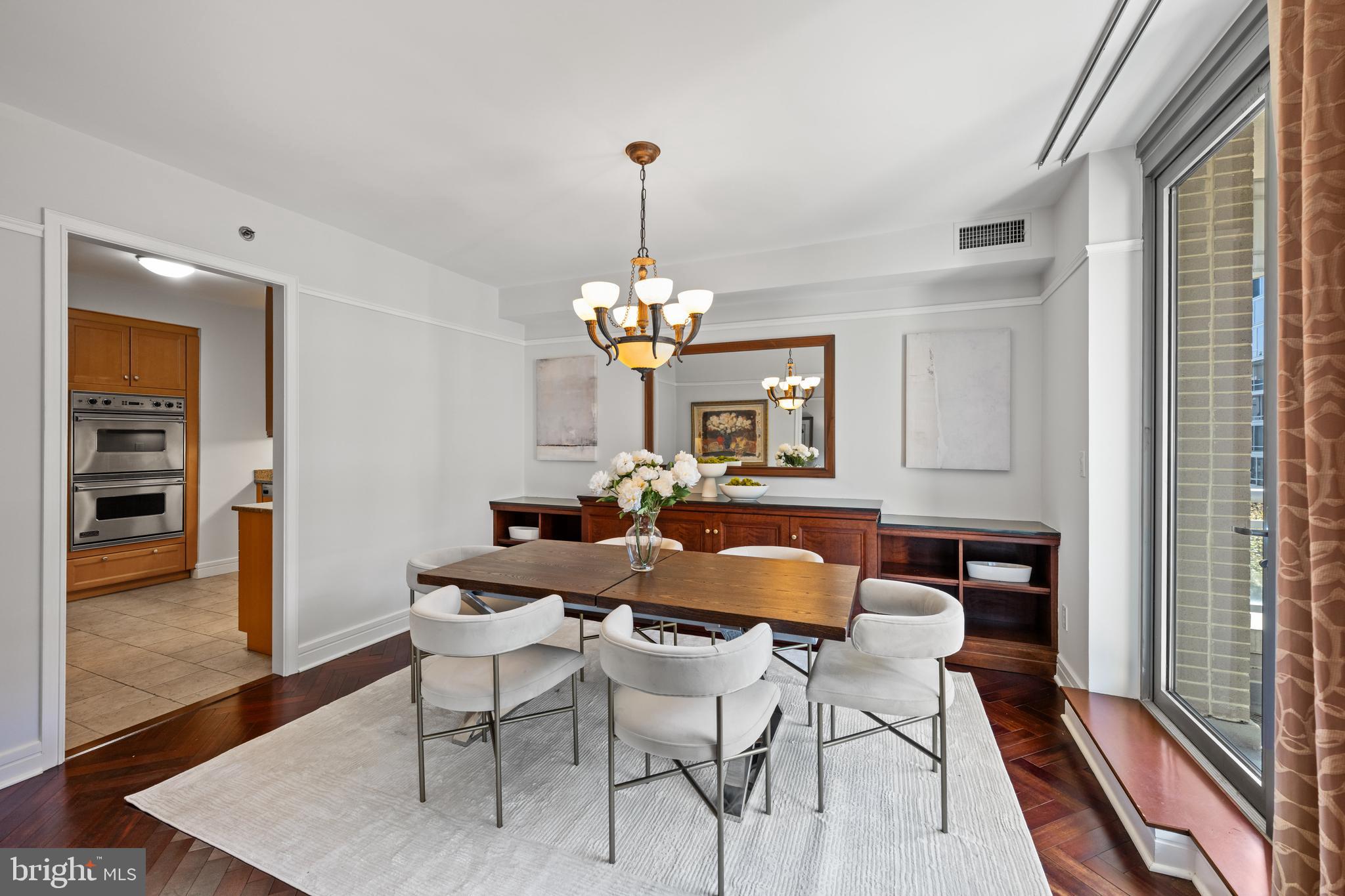 1155 23rd Street Northwest, Unit 6C Washington, DC 20037 - Photo 13 of 32 a dining room with furniture a chandelier and wooden floor