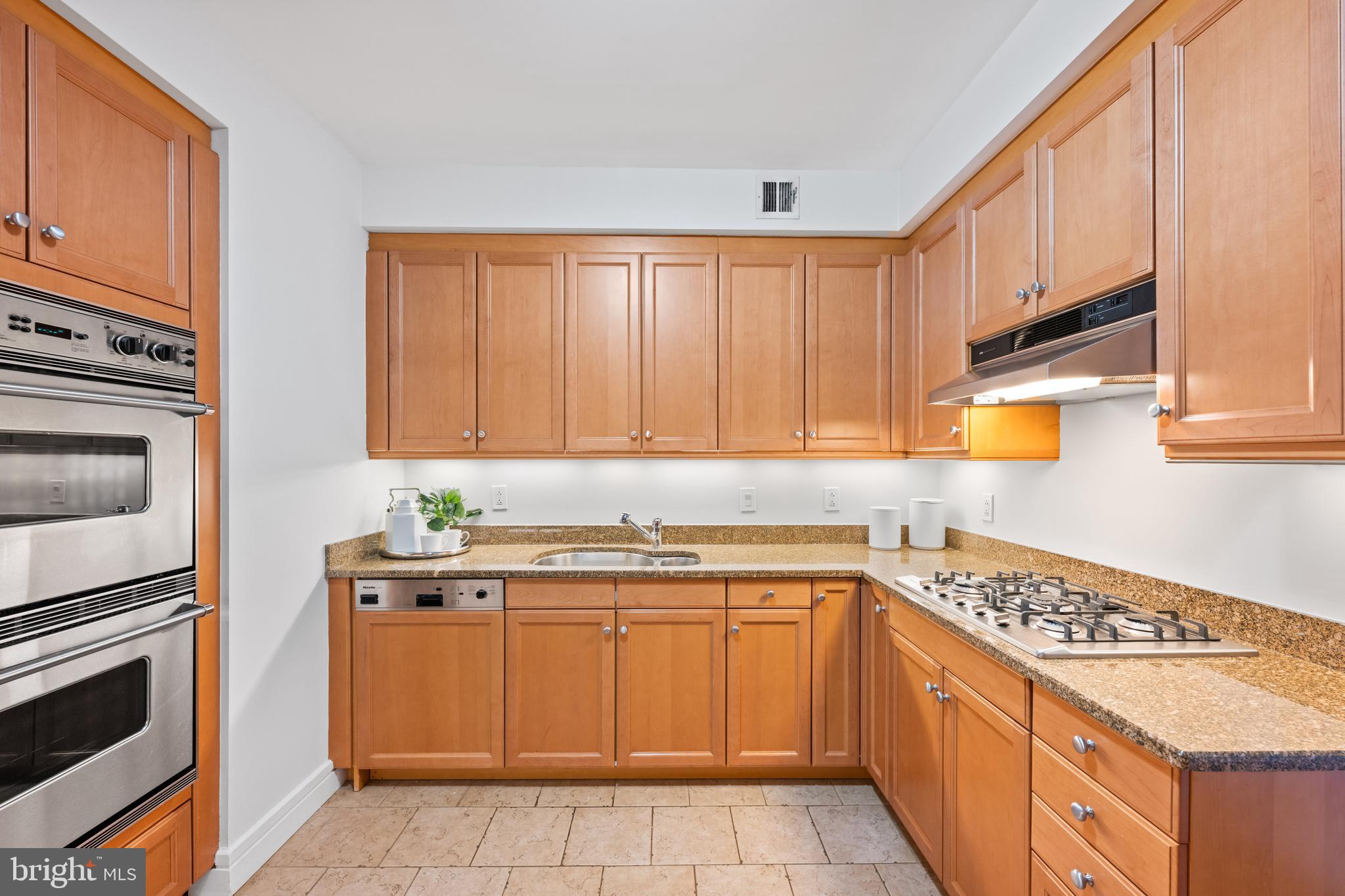 1155 23rd Street Northwest, Unit 6C Washington, DC 20037 - Photo 15 of 32 a kitchen with a sink stove and cabinets