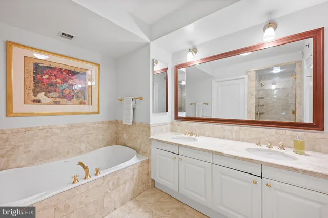 a bathroom with a tub a sink and mirror