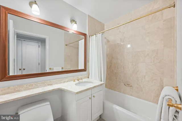 a bathroom with a granite countertop sink a toilet and shower