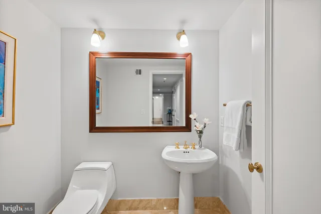 a bathroom with a sink and mirror with toilet