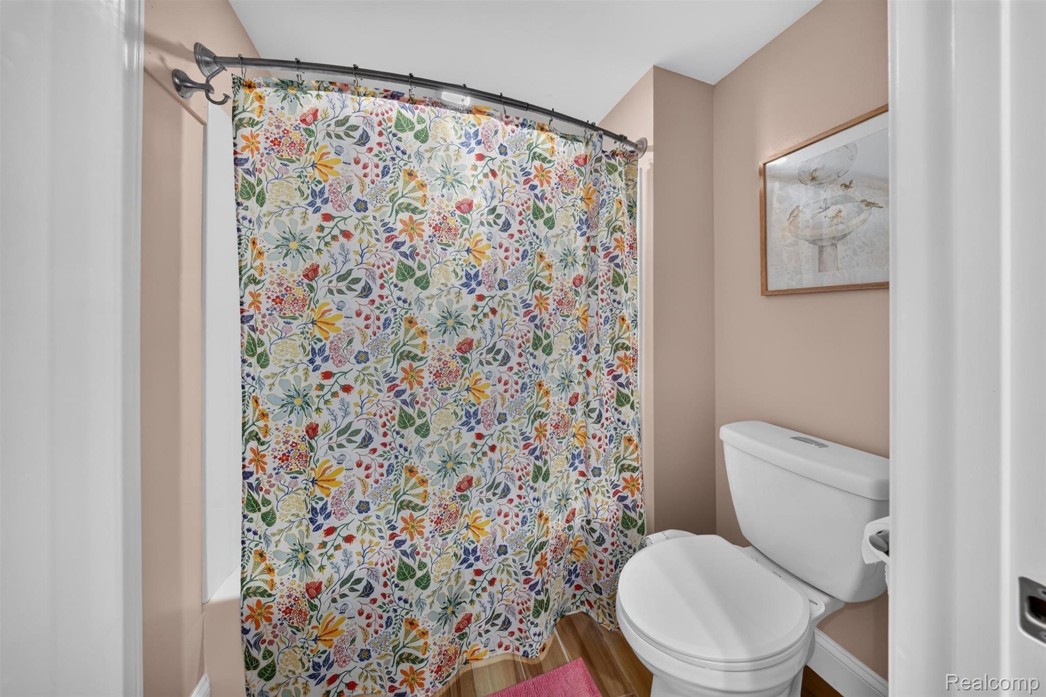 9319 Faussett Road Fenton, MI 48430 - Photo 41 of 70 Wood-finish flooring with a white toilet and a curved shower rod