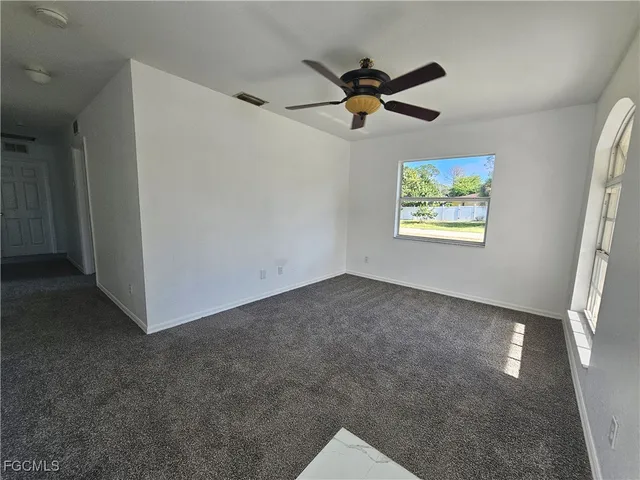 a view of a livingroom with a ceiling fan and window