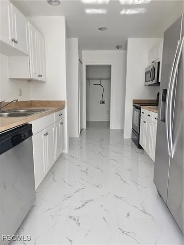 a kitchen with a refrigerator sink and cabinets
