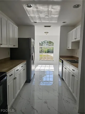 a kitchen with stainless steel appliances a refrigerator sink and cabinets