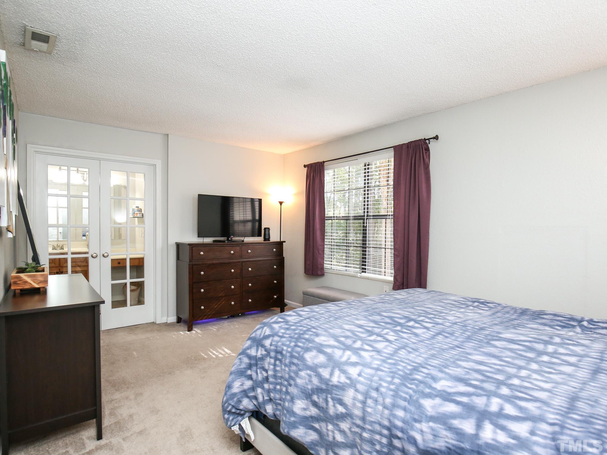 2429 Condor Court, Unit 2429 Raleigh, NC 27615 - Photo 15 of 26 a bedroom with a bed and a flat screen tv