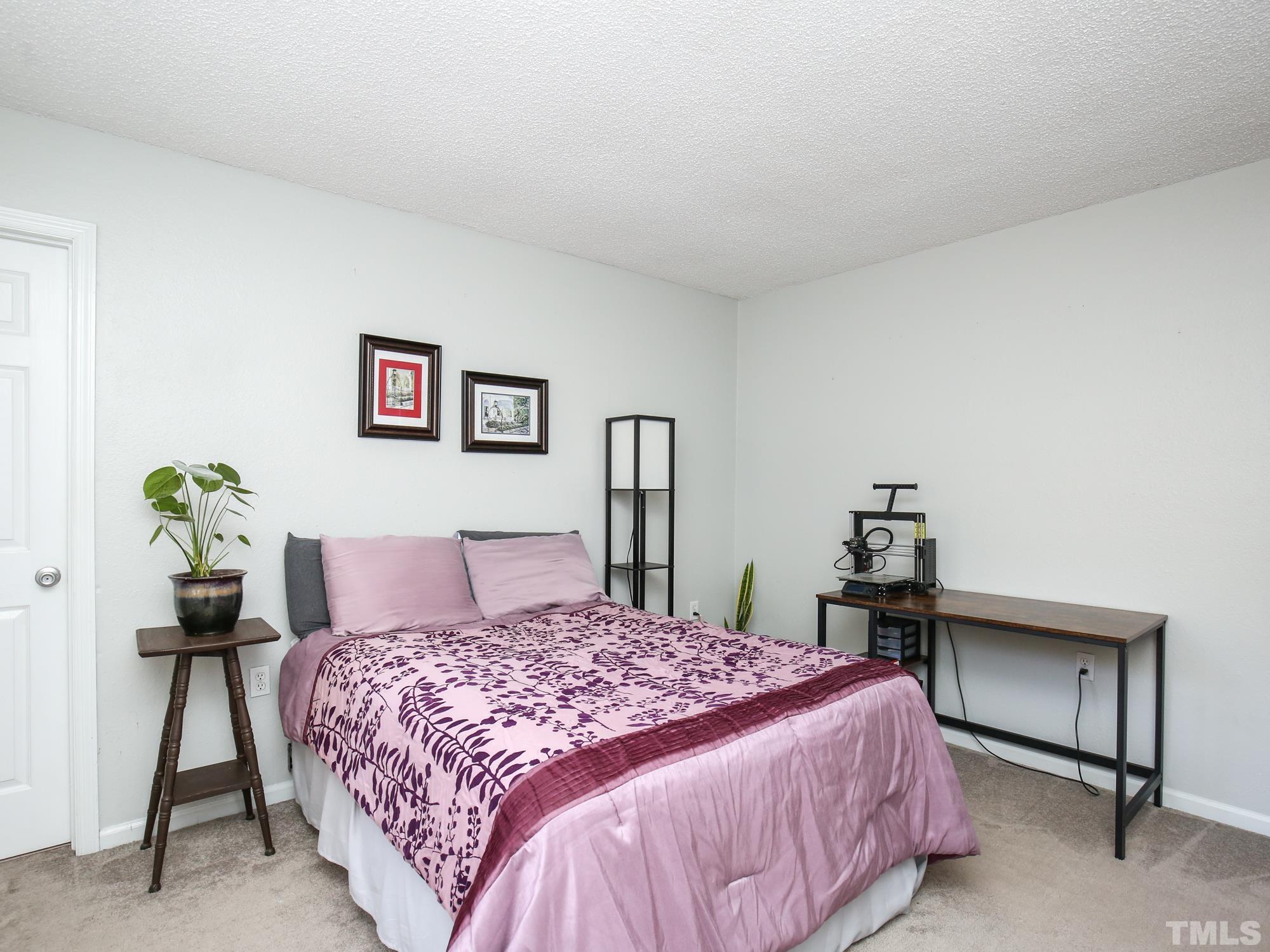 2429 Condor Court, Unit 2429 Raleigh, NC 27615 - Photo 21 of 26 a bedroom with a bed and a table in it