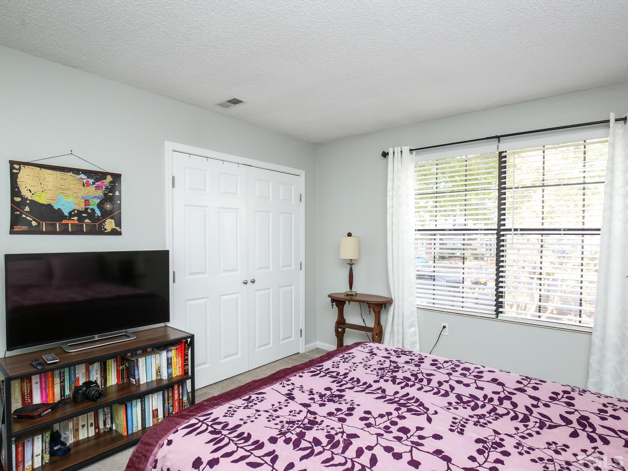 2429 Condor Court, Unit 2429 Raleigh, NC 27615 - Photo 22 of 26 a bedroom with a bed and a flat screen tv