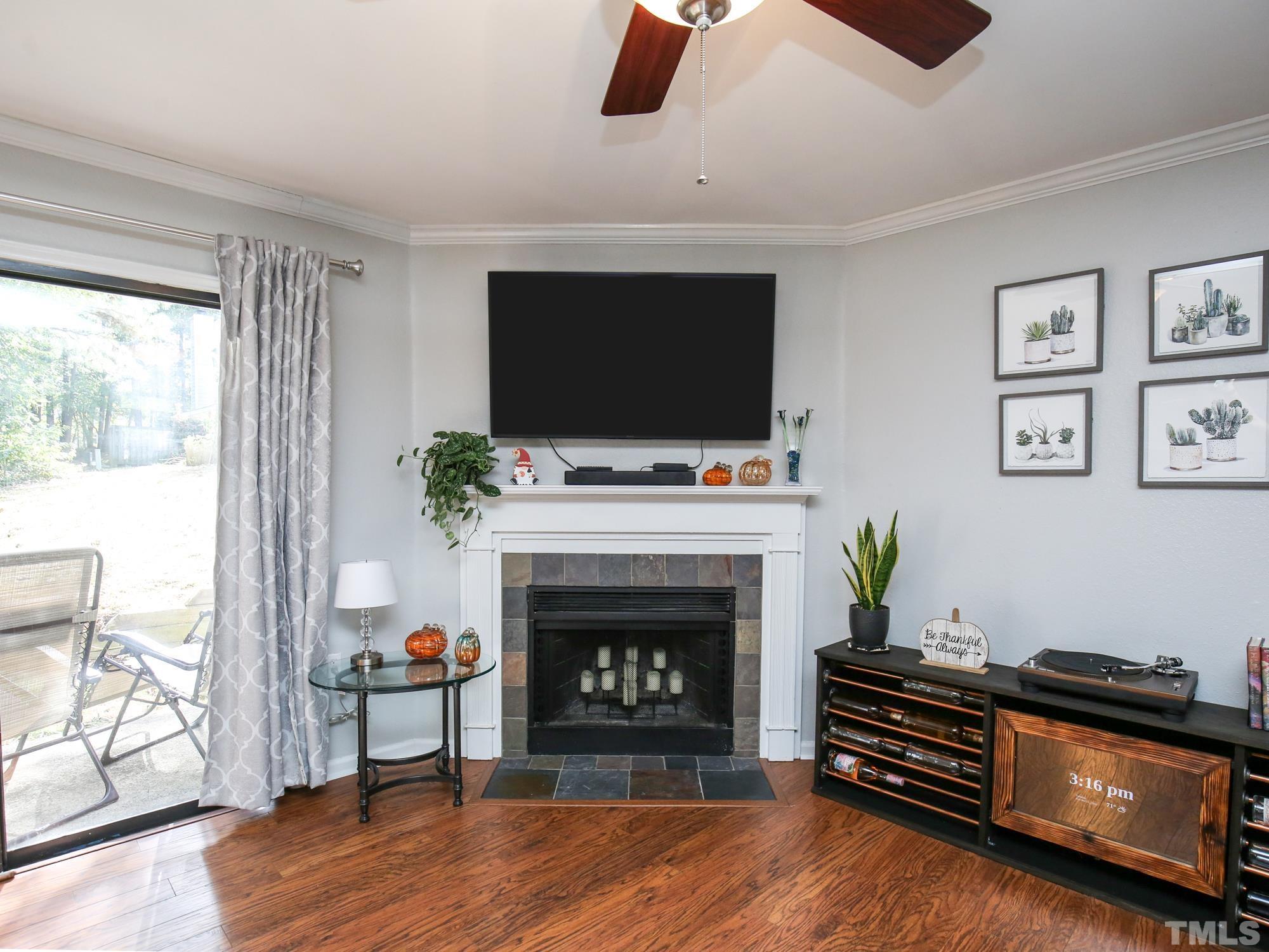 2429 Condor Court, Unit 2429 Raleigh, NC 27615 - Photo 3 of 26 a living room with furniture a flat screen tv and a fireplace