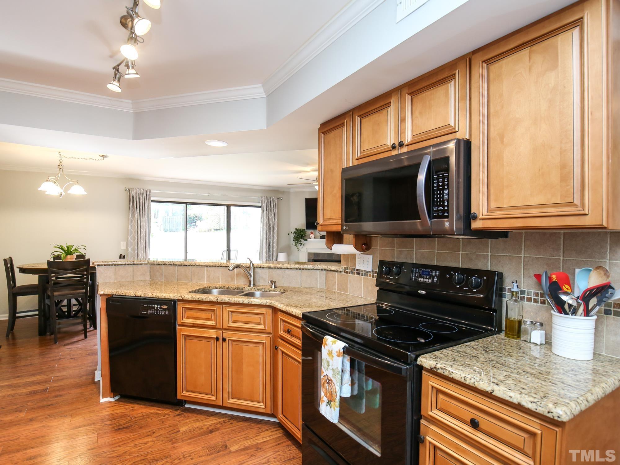 2429 Condor Court, Unit 2429 Raleigh, NC 27615 - Photo 7 of 26 a kitchen with granite countertop stainless steel appliances and wooden cabinets