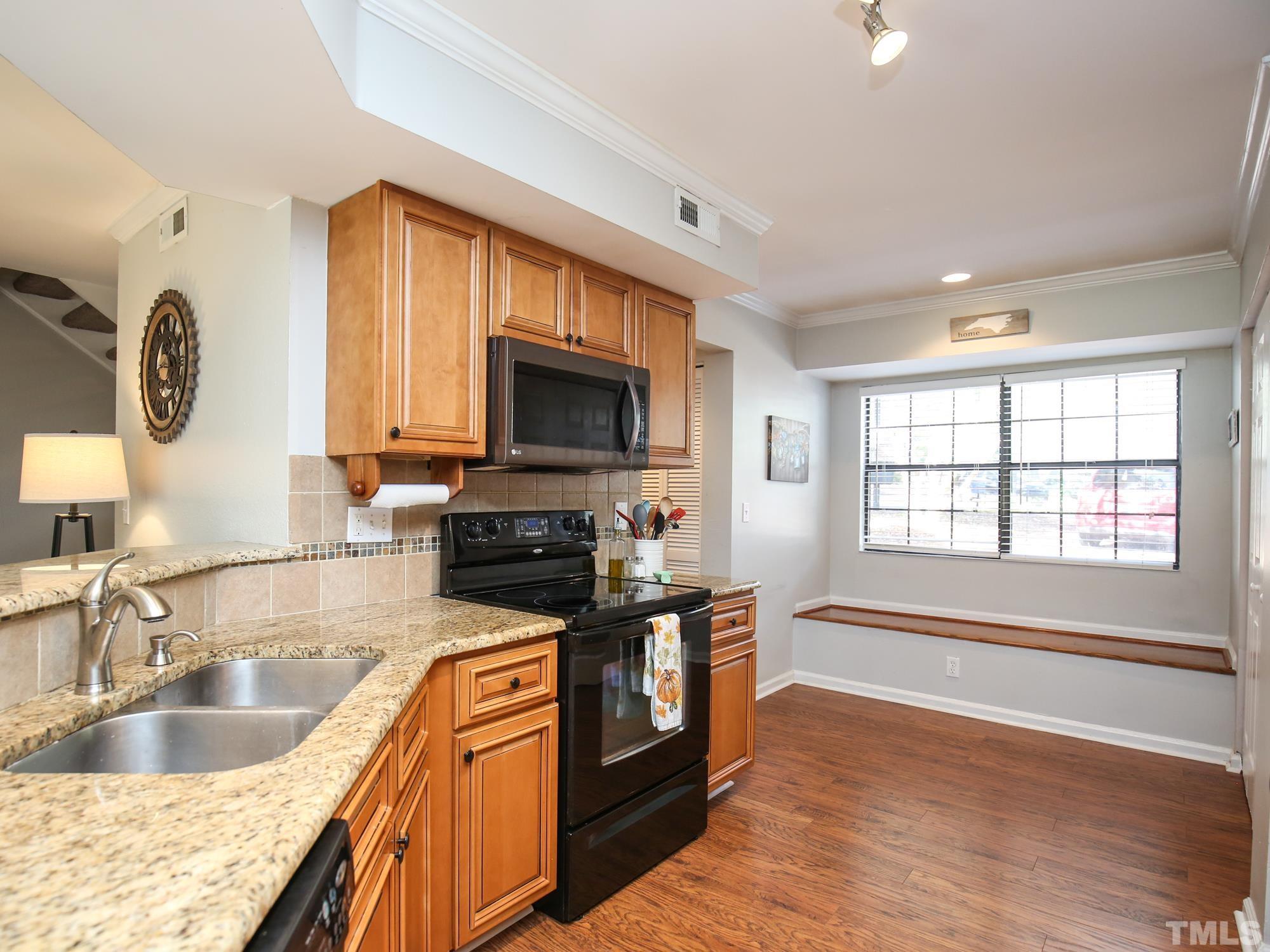 2429 Condor Court, Unit 2429 Raleigh, NC 27615 - Photo 9 of 26 a kitchen with granite countertop a stove and a sink