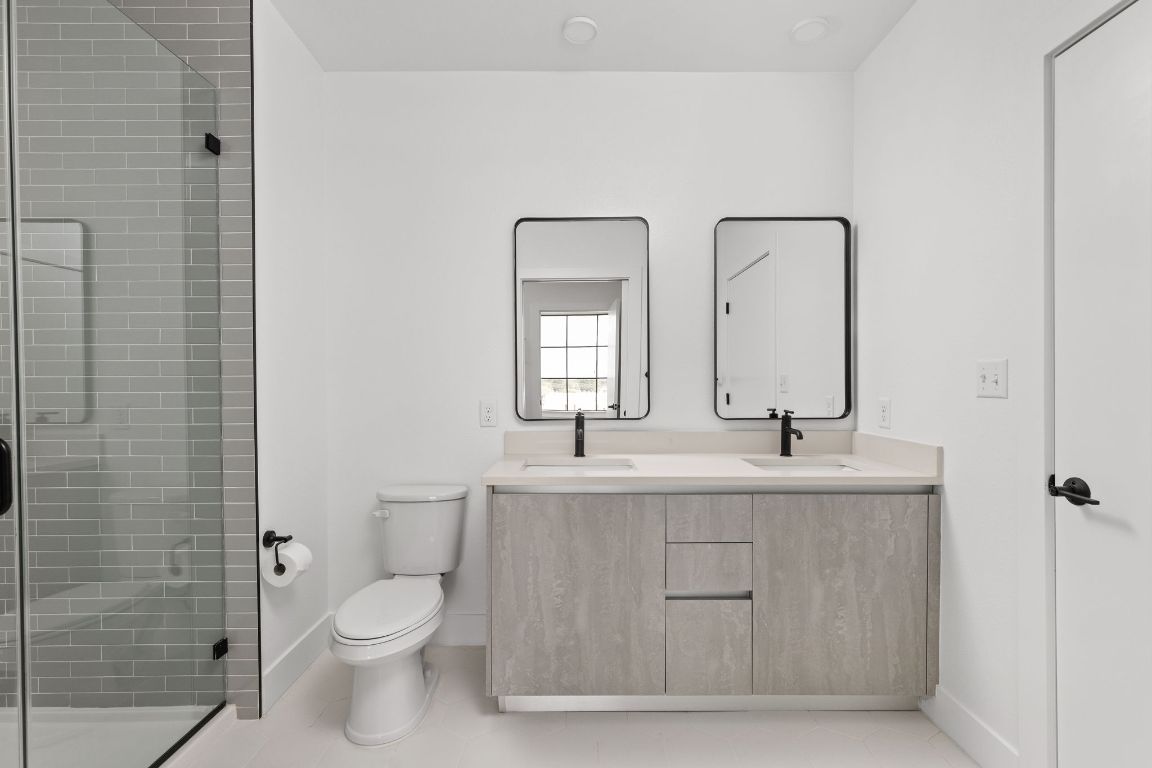 4315 South Congress Avenue, Unit 523 Austin, TX 78745 - Photo 11 of 32 a bathroom with a granite countertop toilet a sink and mirror