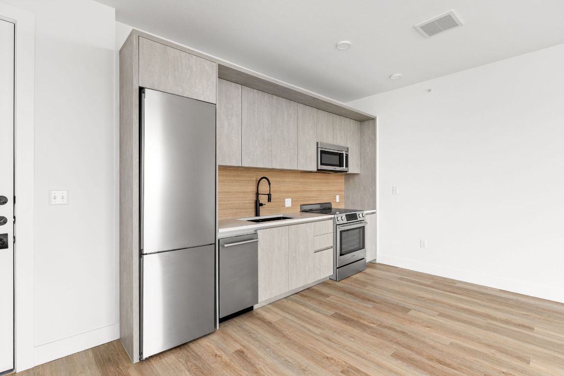 4315 South Congress Avenue, Unit 523 Austin, TX 78745 - Photo 4 of 32 a kitchen with a refrigerator and a stove top oven