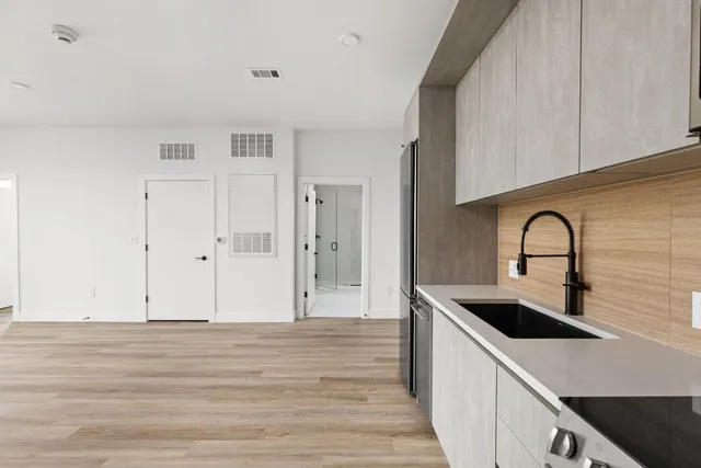 a kitchen with a refrigerator and a stove top oven