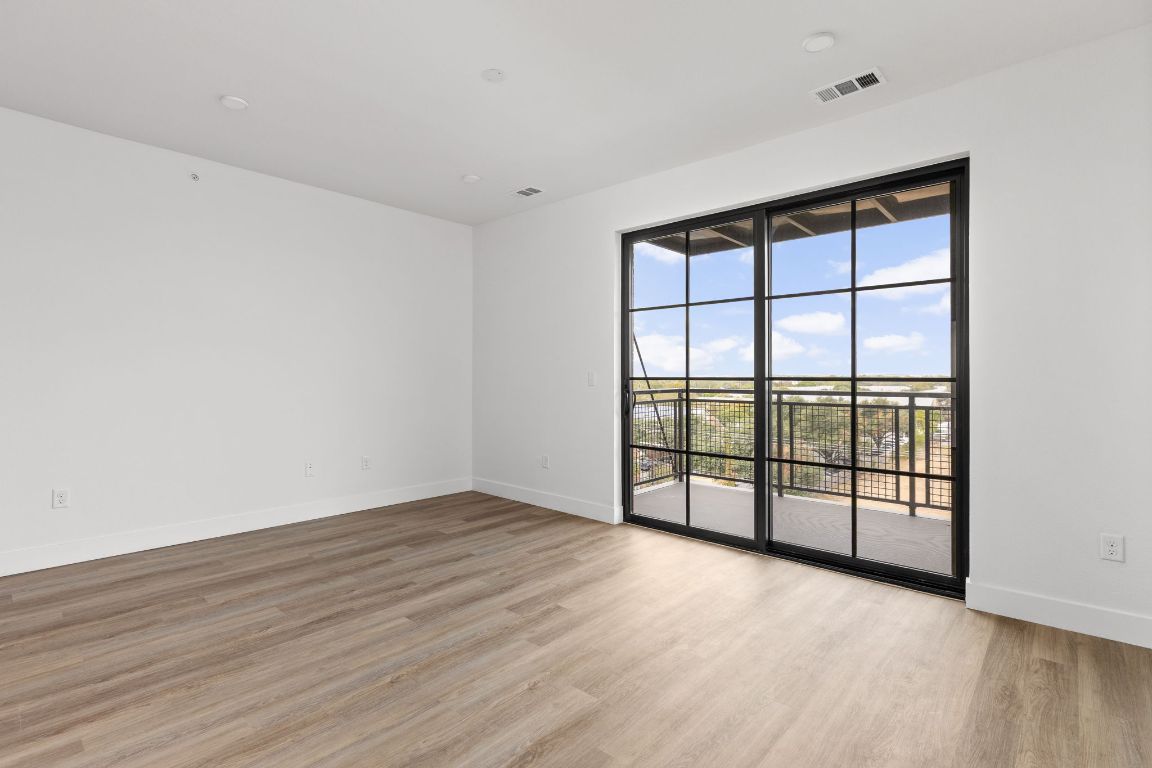 4315 South Congress Avenue, Unit 523 Austin, TX 78745 - Photo 7 of 32 wooden floor in an empty room with a window