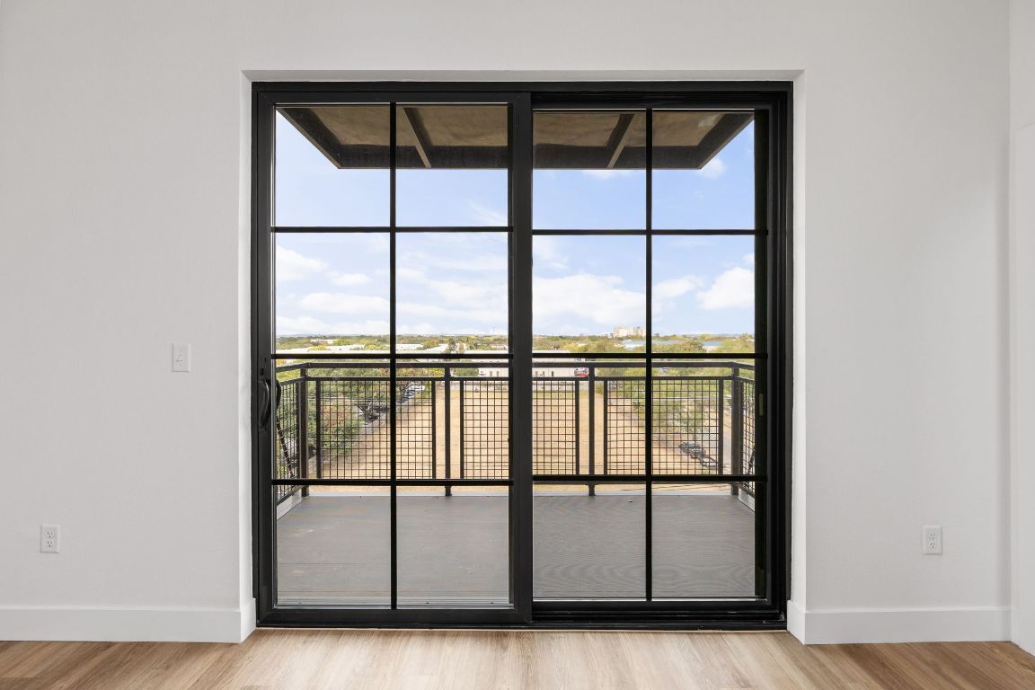 4315 South Congress Avenue, Unit 523 Austin, TX 78745 - Photo 8 of 32 an empty room with wooden floor and windows