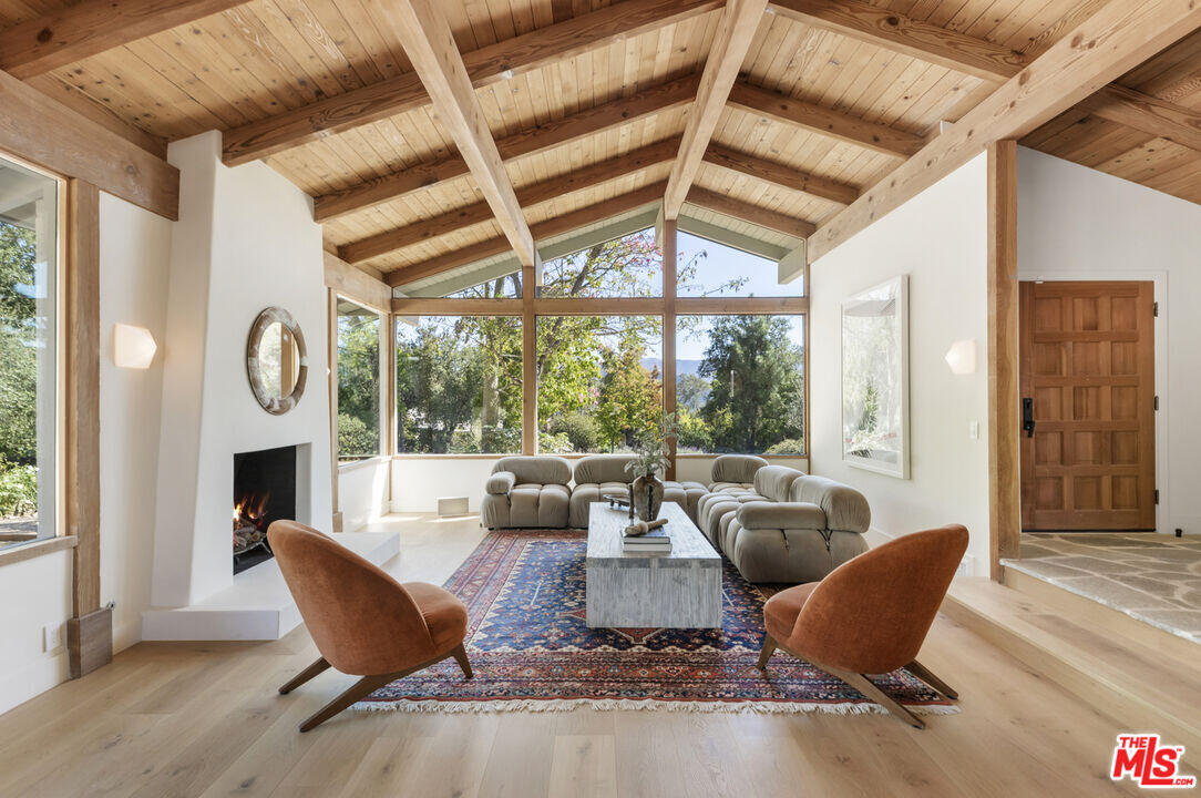 a living room with furniture a fireplace and a large window