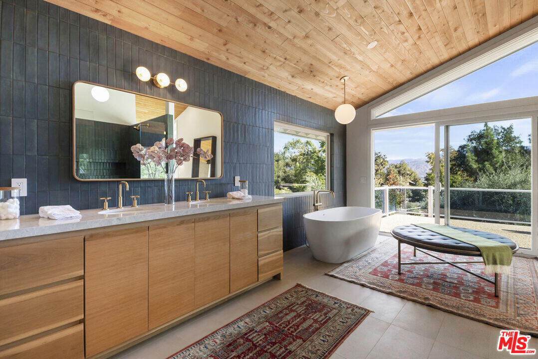 545 Del Oro Drive Ojai, CA 93023 - Photo 38 of 67 a spacious bathroom with a double vanity sink a large mirror and a bathtub